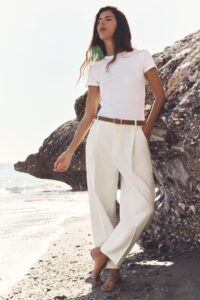 White crew neck tee with creamy white tailored trousers and tan leather belt