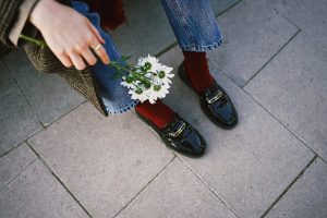 Stylish outfit with polished shoes, jeans, and daisies for a chic casual look.