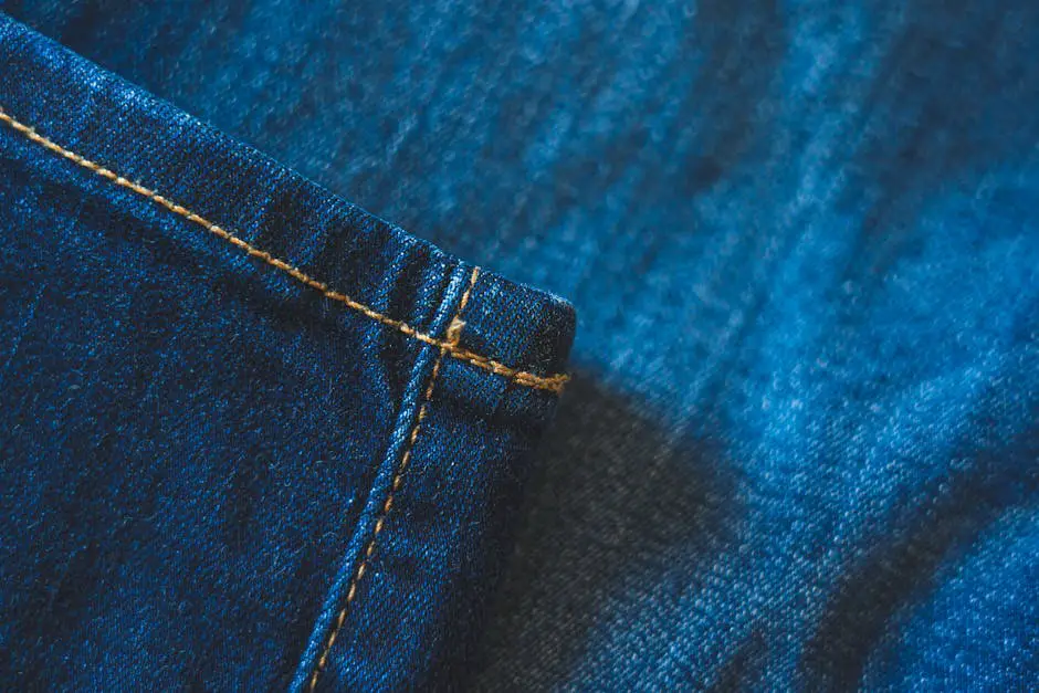 Detailed close-up view of blue denim jeans fabric showcasing visible stitching and texture.