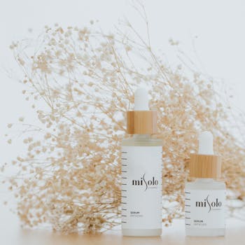 Elegant serum bottles displayed with baby's breath on a light background.